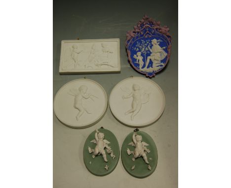 A pair of continental bisque circular wall plaques; one other rectangular example; and three single examples 