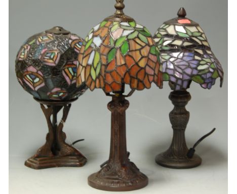 A Tiffany style bronzed metal table lamp with glass shade and two other similar (3)