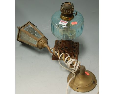 A cast metal and glass pedestal oil lamp, a reproduction brass wall light etc 