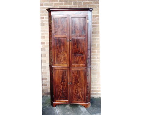 A GEORGIAN INLAID MAHOGANY STANDING CORNER CUPBOARD the upper portion with pair of panelled doors enclosing four shelves with