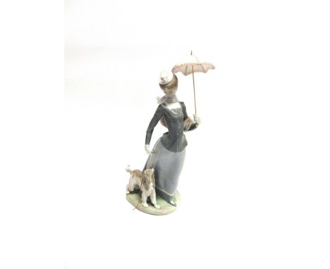 A LARGE LLADRO FIGURE OF A LADY  walking a dog whilst holding a parasol, 43cm high