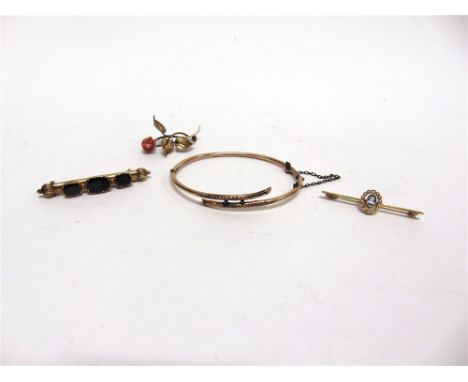 AN AQUAMARINE AND SEED PEARL BAR BROOCH stamped '15ct', 3.4g gross; a coral spray brooch; a three stone garnet brooch; and a 