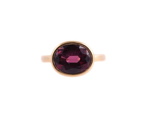 
	
		A SINGLE STONE GARNET RING 
		LONDON 2018
		The oval cut garnet within a collet setting, makers mark LE
		Size/dimension