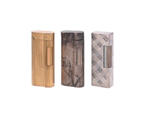 
	
		THREE DUNHILL LIGHTERS
		To include: a gold plated lighter, with reeded decoration, 6.5cm (2 1/2in) high; a matching sil