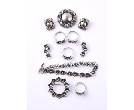 
	
		NIELS ERIK FROM, A SMALL COLLECTION OF VINTAGE SILVER COLOURED JEWELLERY
		Comprising a flower head bracelet, the panel 