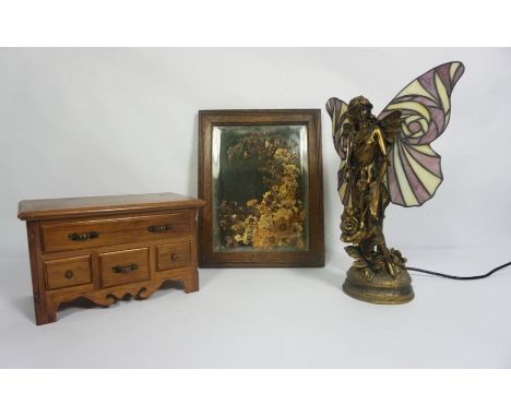 An Art Nouveau style ‘Fairy’ table lamp, with stained glass wings, 40cm high; together with an oak framed decorative mirror w