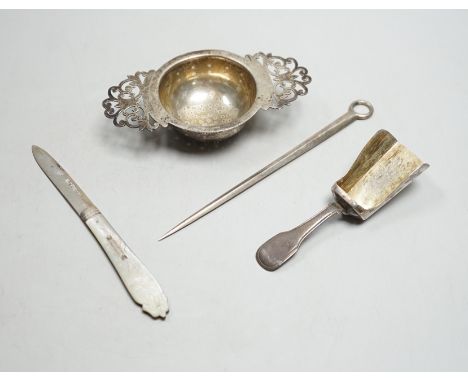 A silver tea strainer, a George III silver 'shovel' caddy spoon, London, 1811, a mother of pearl handled silver fruit knife a