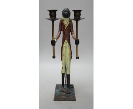 A painted iron novelty two branch monkey candlestick, 44cms high