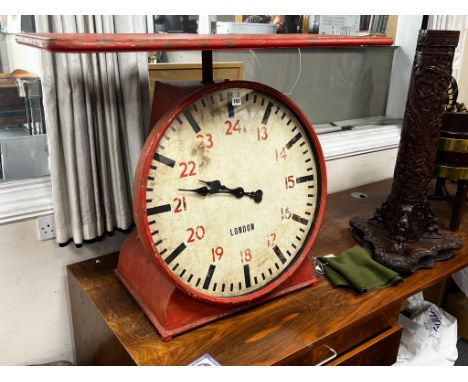 An industrial style painted metal clock console table modelled as a set of scales, width 102cm, depth 46cm, height 80cm.