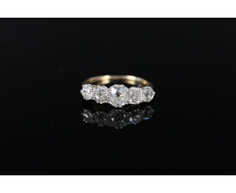 An impressive five stone diamond ring, the graduating old cut diamonds claw mounted in white metal, the central diamond appro