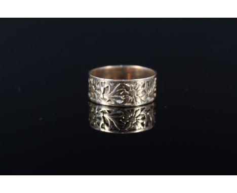 An unmarked yellow metal band ring with engraved floral decoration (worn), size P, approx 3.5g