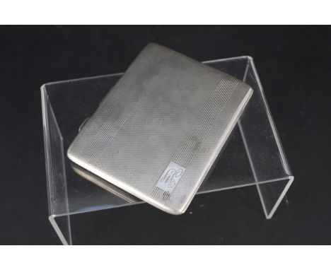 A large silver cigarette case with engine turned decoration engraved with initials to front and presentation inscription to i