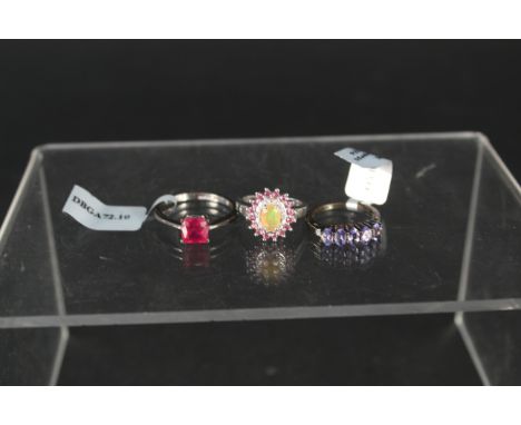 Three silver stone set rings, tanzanite and diamond, opal and diamond and 2.6ct ruby, all with certificates