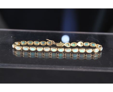 An 18ct gold opal set bracelet consisting of twenty seven oval collet set opals, clasp stamped 750 18K, approx 16g