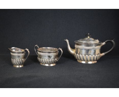 A Victorian silver three piece tea set, comprising a tea pot, sugar and cream, of oval form having a moulded rim  with gadroo