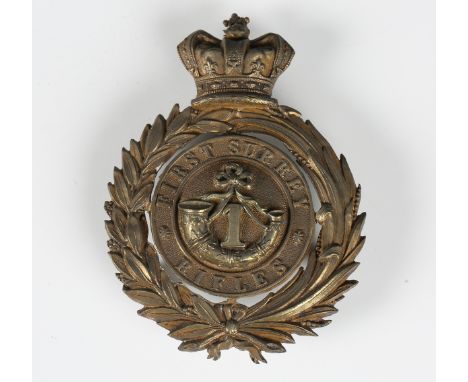 A Victorian gilt metal helmet plate badge for the First Surrey Rifles, the back with three screw post fixings, height 8cm.Buy