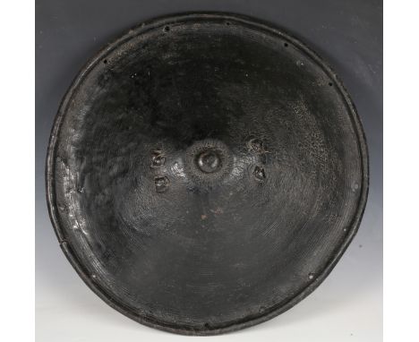 A large late 19th/early 20th century North African rhinoceros hide shield of circular form with raised umbonate centre boss, 