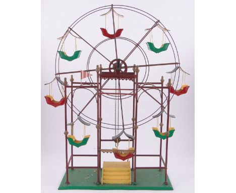 A large Edwardian metal-framed Ferris wheel with painted tinplate swings,on metal stand, used as a shop window display item b