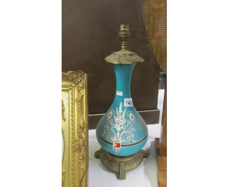 A brass and glass lamp base with hand painted decoration