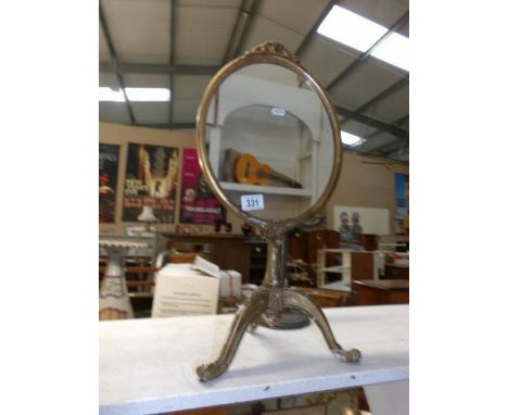 A metal framed mirror on tripod base
