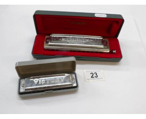 A cased Hohner super Chronomica and a Victory Harmonica