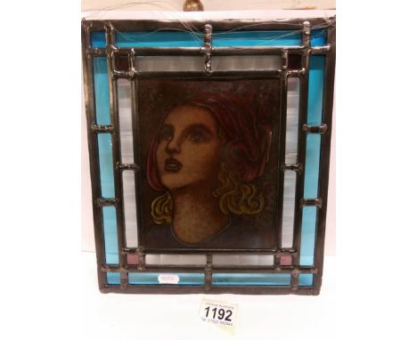 A leaded and stained glass panel with female portrait