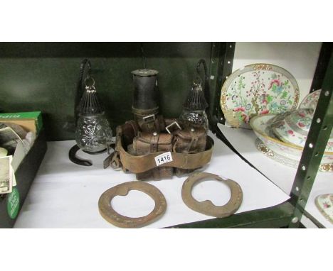 2 horseshoe and nails lamps, a miner's lamp, an ammo belt and a pair of hunters shoes