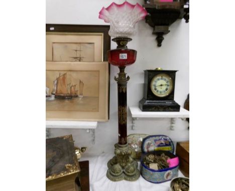 A 19th century oil lamp on ornate brass base with gilt decorated ruby glass column, ruby glass font and cranberry edged shade