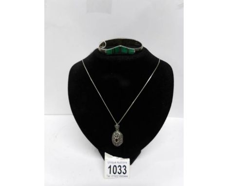 A silver bangle and locket