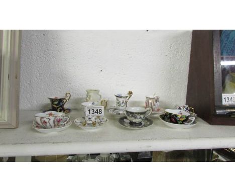 8 various miniature tea cups and saucers together with a miniature Toby jug