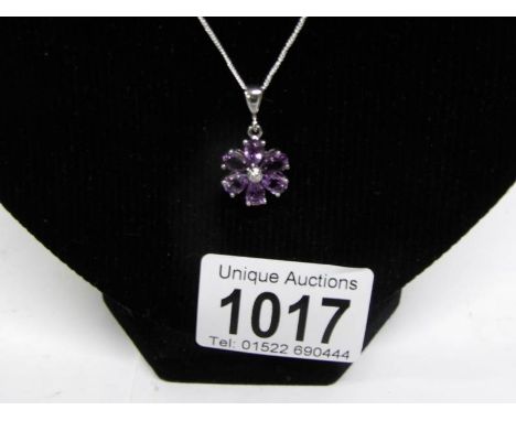 An amethyst floral pendant with diamond centre