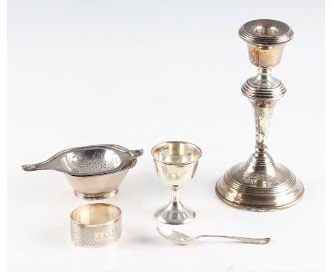 A collection of hallmarked silverware, to include a weighted silver candle stick, hallmarked Birmingham 1959, a silver egg cu