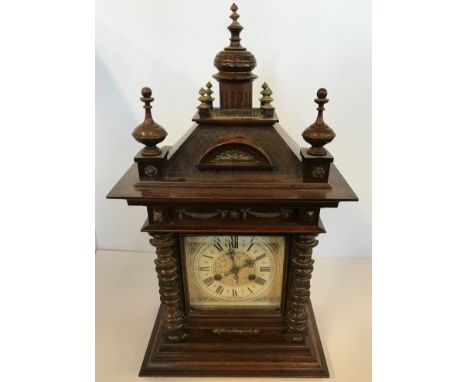 An Unghans mahogany cased German mantle clock with turned column sides and finial top.