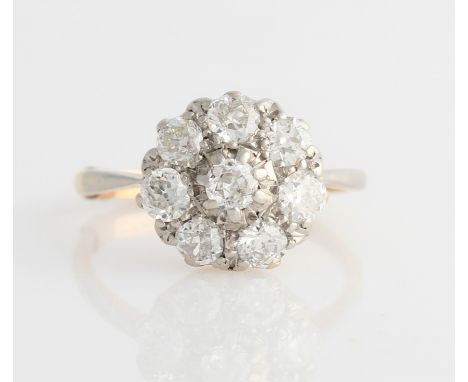 A diamond flower cluster ring, set with a central old cut diamond, surrounded by a border of seven round and old cut diamonds