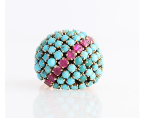 A turquoise and ruby set cluster ring, set with a cluster of round cut reconstituted turquoise cabochons featuring diagonal l