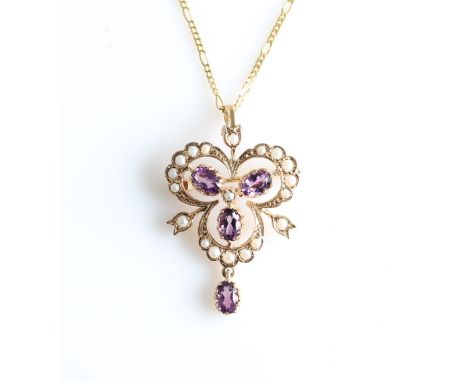 A 9ct yellow gold amethyst and seed pearl pendant, set with three central oval cut amethysts, surrounded by seed pearl set op