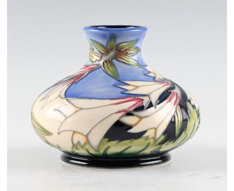 A Moorcroft bulbous vase with Ivory Bells pattern on light blue background, designed by Philip Gibson. Height 10.5cm