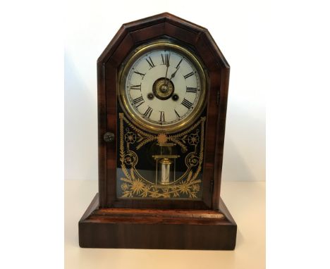 A mahogany and rosewood mantle clock with single glazed door and Roman numerals