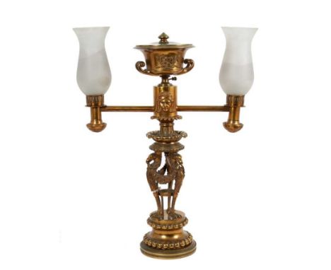 Good George IV brass twin light Argand oil lamp, now converted to electricity, with urn surmount and trophy crest and mask or