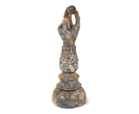 Antique composition garden finial, in the form of a forearm, holding a ball, 41cm high