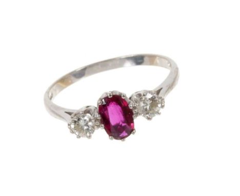 Ruby and diamond three stone ring with an oval mixed cut ruby flanked by two brilliant cut diamonds in claw setting on 18ct w