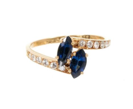 Cartier sapphire and diamond cross-over ring with two marquise cut blue sapphires in a cross-over design with graduated brill