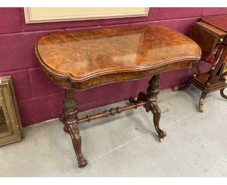 Victorian burr walnut veneered card table with shaped fold-over top on carved and turned supports with turned stretcher on ca