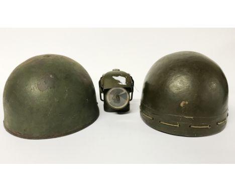 Two World War II British dispatch riders helmets (one steel) and  a World War II army issue cycle lamp.