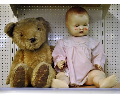 A large vintage Teddy Bear and a celluoid doll, both 55cm.