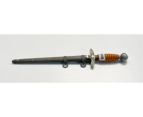 A Nazi Luftwaffe dagger in scabbard with orange handle.