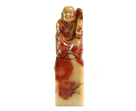 A Chinese carved figural mixed colour hardstone seal of the Buddha with a ruyi, H. 10.5cm.