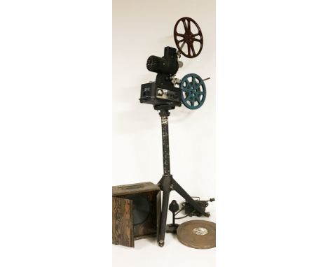 A cinetechnic film projector and stand together with cased speaker and two film reels (one is "Brothers in the Wind").