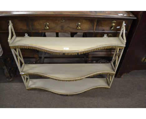 Painted three tier shelf of serpentine form, 92cm wide