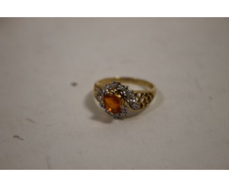 A 9 CARAT GOLD RING SET WITH A FIRE OPAL TYPE CENTRE STONE 